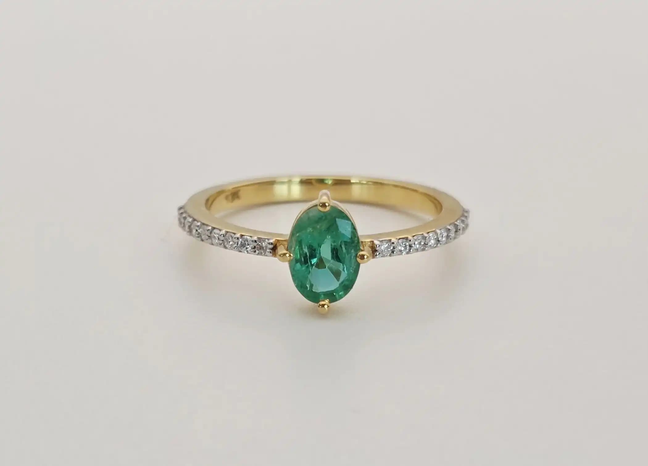 0.64 cts oval natural emerald solitaire ring in 18K yellow gold