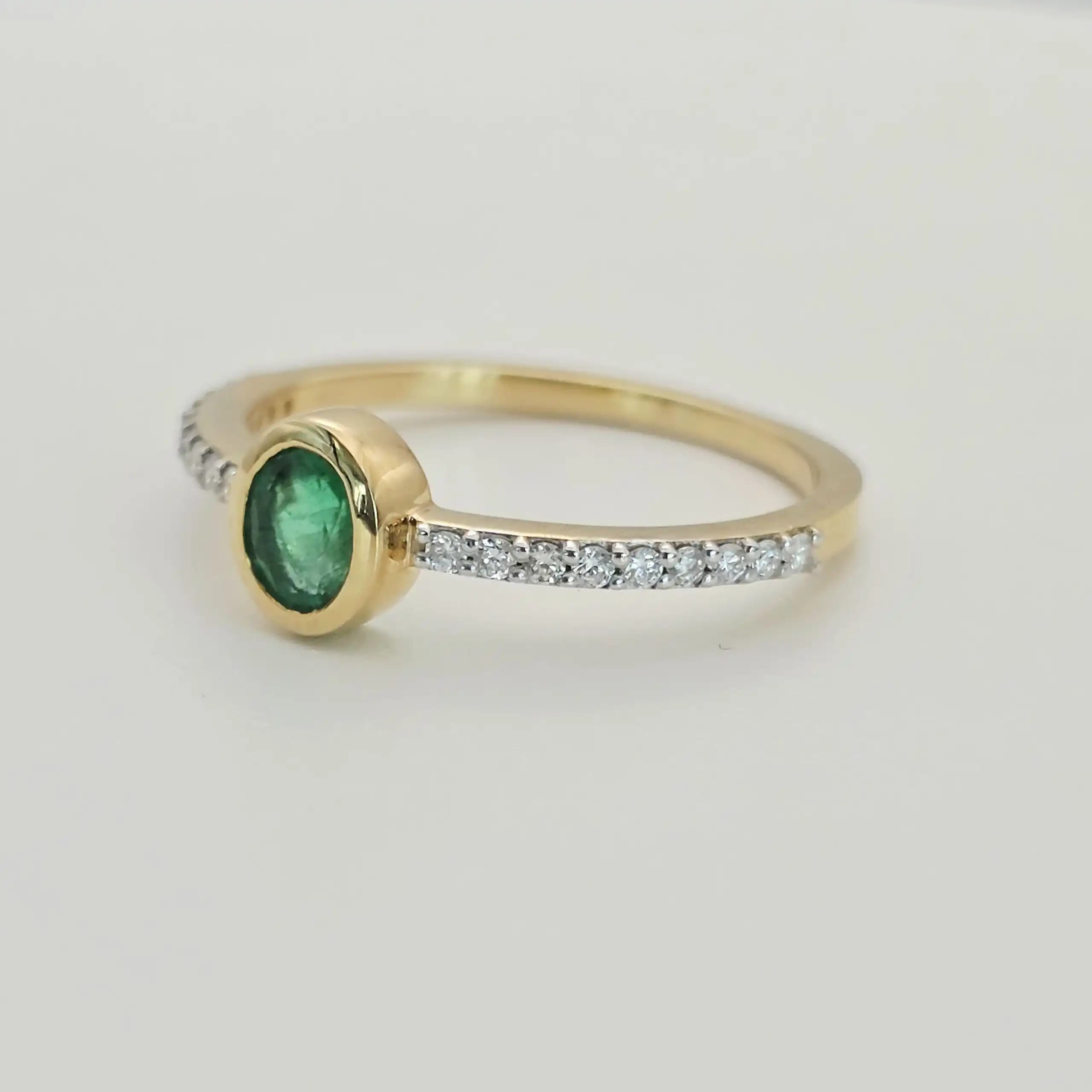 0.31 cts oval natural emerald bezel ring in 18K yellow gold