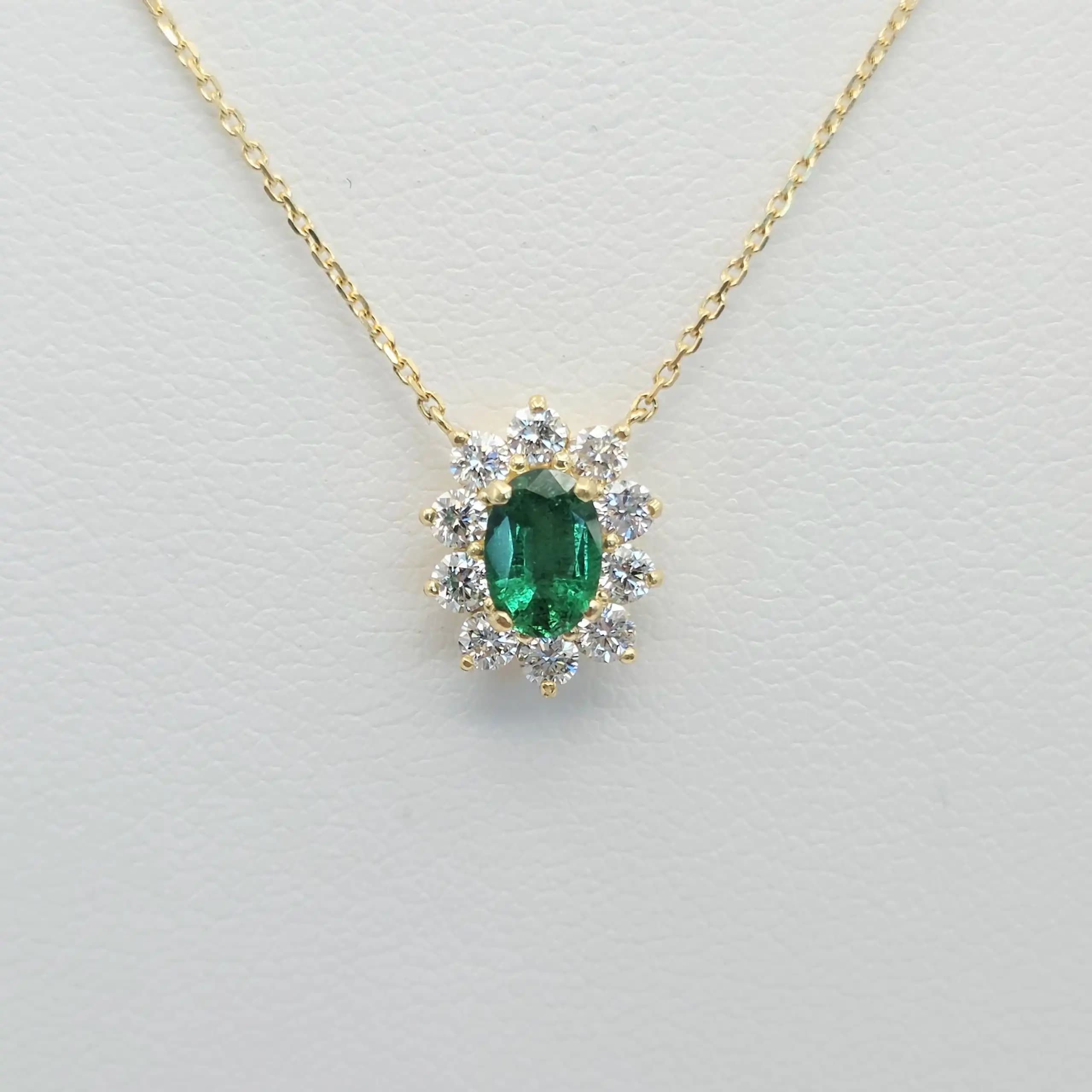 0.40 cts oval natural emerald and diamond halo pendant in 18K yellow gold