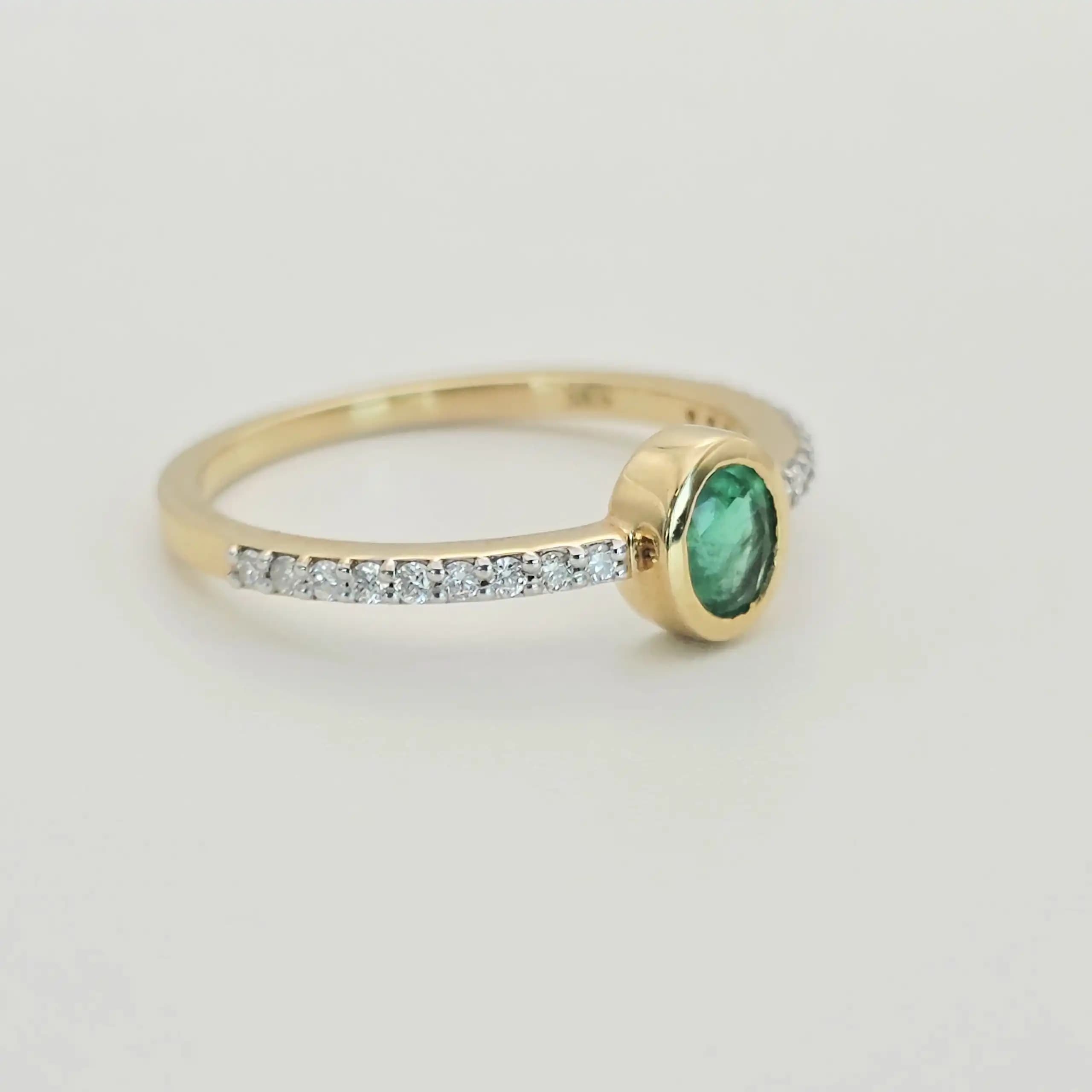 0.31 cts oval natural emerald bezel ring in 18K yellow gold