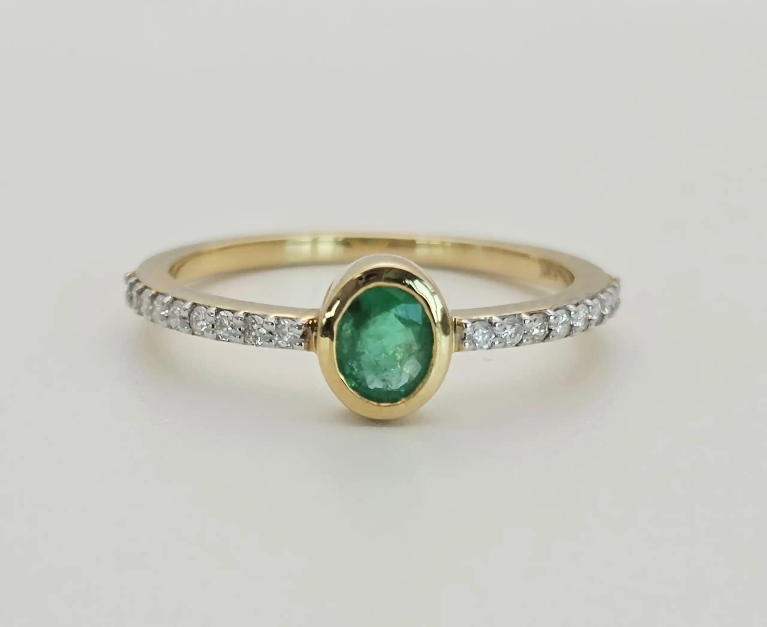 0.31 cts oval natural emerald bezel ring in 18K yellow gold