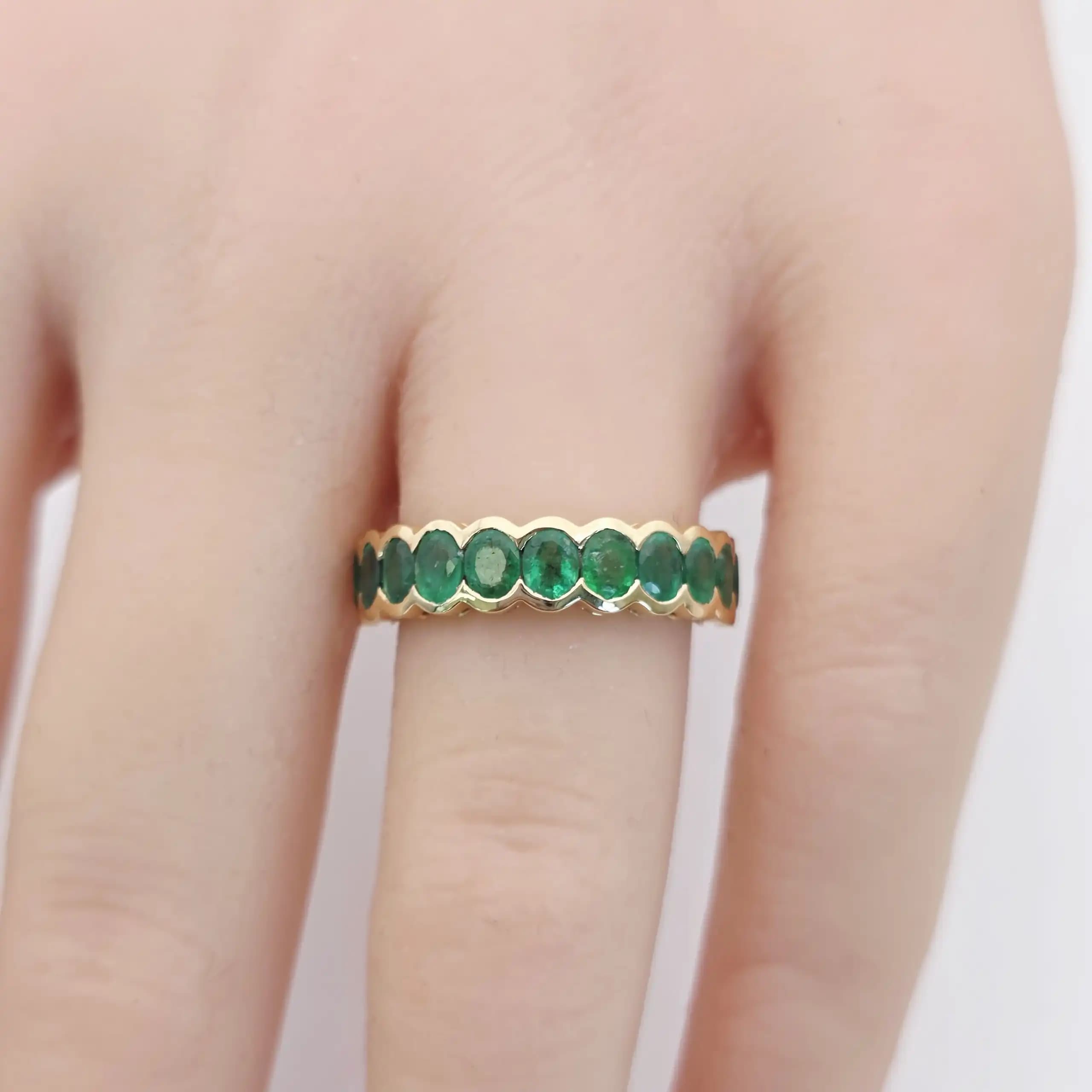 1.69 cts oval natural emerald bezel eternity ring in 18K yellow gold
